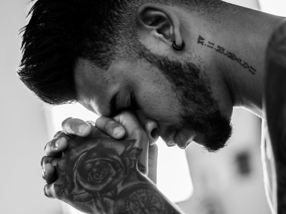 man tattooed praying